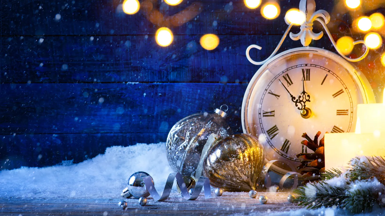 White clock and gold lights in front of blue planks on the snow