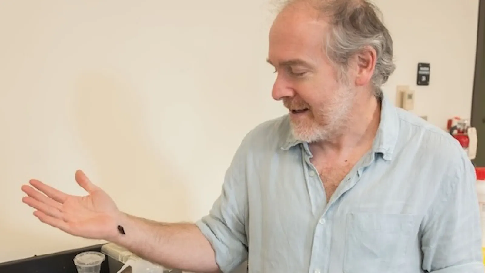 Muñoz-Garcia holding cockroach on outstretched arm