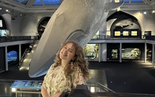 Chloe Kenyon standing in front of whale model at museum