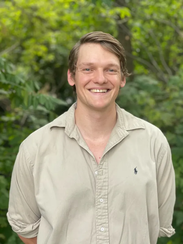 James Dowling standing in front of wood line