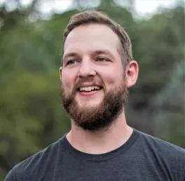 headshot of Rob Denton standing outdoors in front of tree line