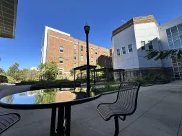new table and chair in shaded corner overlooking Jennings courtyard and trellises